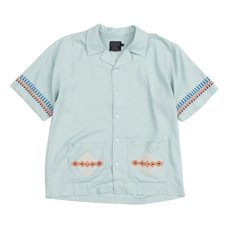 A green camp collar shirt with Pendleton needlework detail on the pockets and sleeves, displayed on a white background.